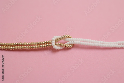 Luxury beaded bracelet on pink background with copy space.