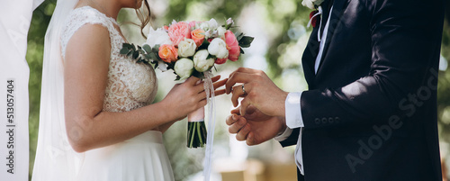 Groom put a ring on finger of his lovely wife. Wedding engagement rings. Married couple exchange wedding rings at a wedding ceremony. Concept wedding details. Happy family. Together. photo