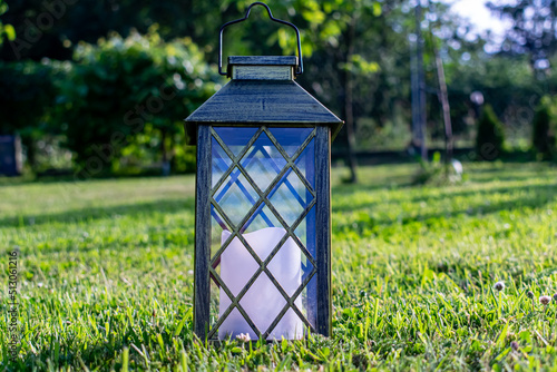 A garden lantern on the background of summer grass.