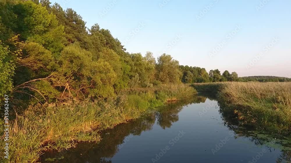 Aerial shot of a countryside field with a river in the evening Aerial shot of a countryside field with a river in the evening