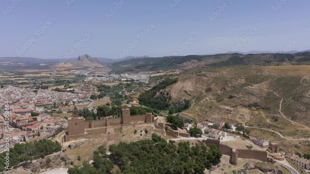Beautiful Castle of Antequera viewed from above. Drone rotating around the building, In background the mountain Beautiful Castle of Antequera viewed from above. Drone rotating around the building, In background the mountain