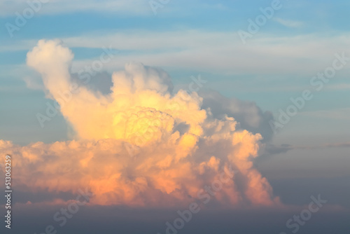 Large orange cumulonimbus cloud in the evening at sunset photo
