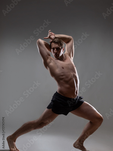 Tela Muscular man in an artistic pose, portrait on a gray background