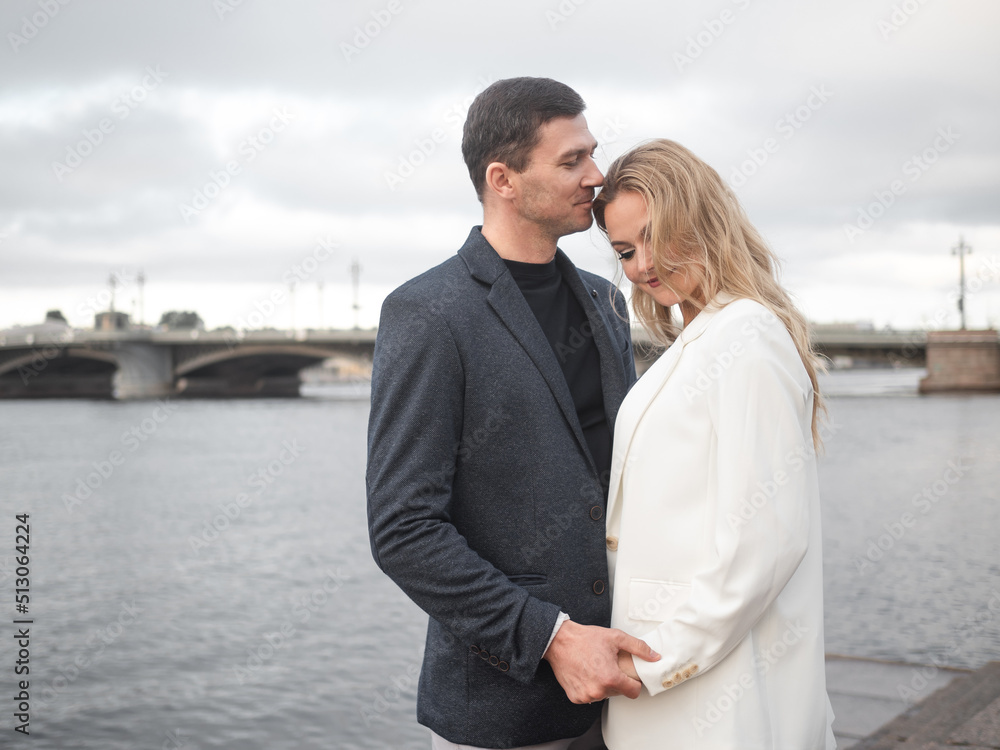couple, a young man and a woman are standing near a river, an urban landscape. A couple in love enjoys a city walk couple, a young man and a woman are standing near a river, an urban landscape. A couple in love enjoys a city walk