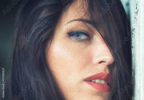 Portrait of beautiful sensual young woman with long brown hair and blue eyes