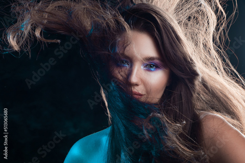 Gorgeous brunette with long beautiful hair. Bright makeup, shining eye shadow. Beautiful styling and makeup, glamorous diva