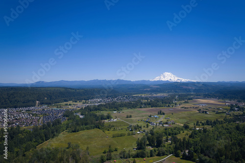 An aerial view of Puyallup, Washington with Mt. Rainier covered in snow under a clear blue sky in the background. photo