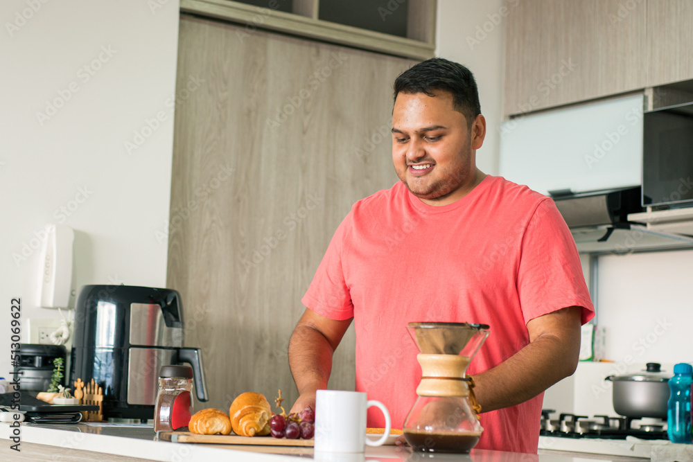 Lifestyle: Man dieting to lose weight and have better health. Correct problems of obesity and sedentary lifestyle. Latin American young adult in the kitchen of his house preparing a healthy breakfast Lifestyle: Man dieting to lose weight and have better health. Correct problems of obesity and sedentary lifestyle. Latin American young adult in the kitchen of his house preparing a healthy breakfast