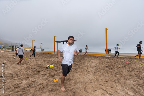 Man running among other people as training on the beach photo