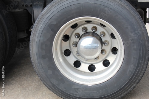 truck tire shows reflection of a sky blue vehicle