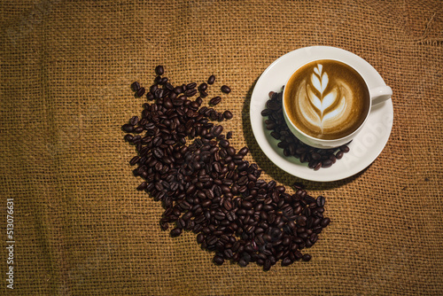 Hot coffee cappucino on the old wooden table. A cup of coffee on a plate. cappucino black coffee. Coffee cup on the wooden background. photo