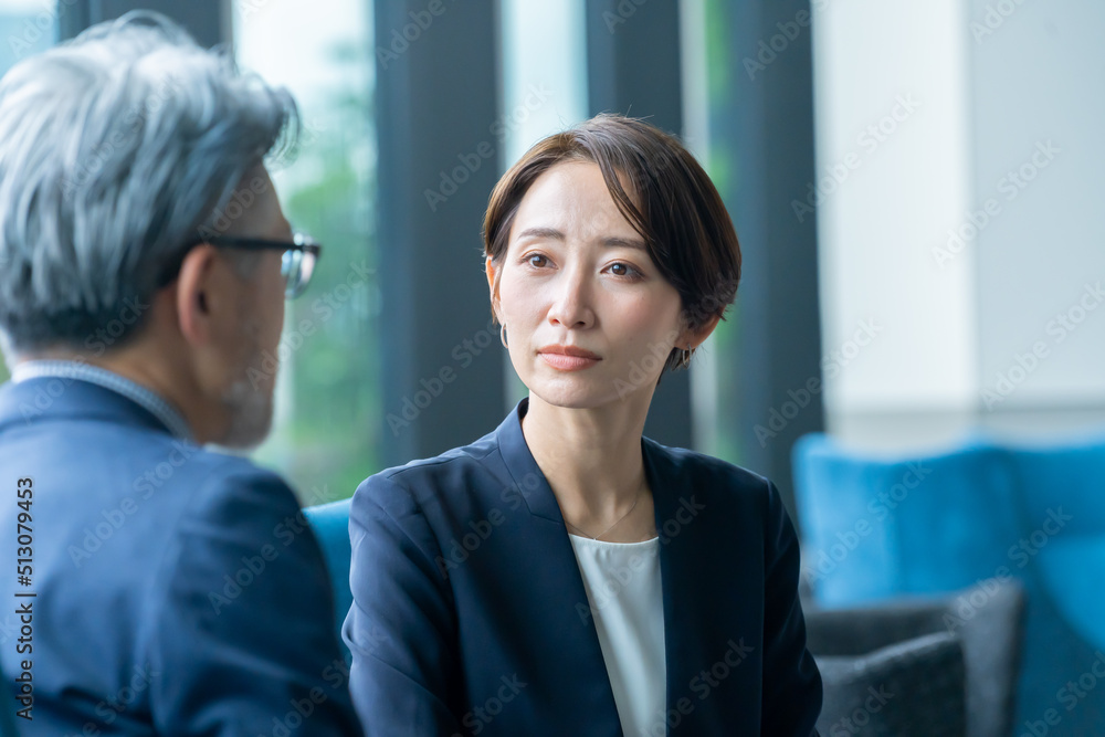 真剣に話を聞くスーツを着た日本人女性 真剣に話を聞くスーツを着た日本人女性
