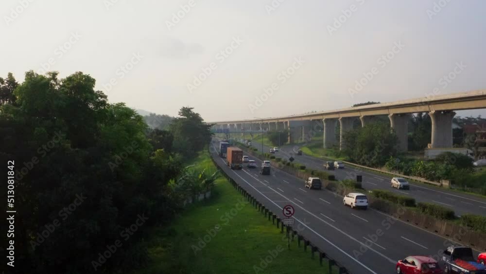 The view of bandung toll road in the evening many vehicles passes smoothly with varying speeds. coupled with the view of green plants along the highway road give a more eye-pleasing atmosphere The view of bandung toll road in the evening many vehicles passes smoothly with varying speeds. coupled with the view of green plants along the highway road give a more eye-pleasing atmosphere