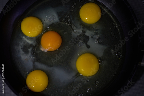 Five eggs in a frying pan in olive oil