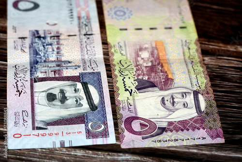 Saudi Arabia 5 SAR five Saudi riyals cash money banknote with the photo of king Salman, king Abdullah, Shaybah oil refinery and Ras Tanura oil refinery isolated on a wooden background photo