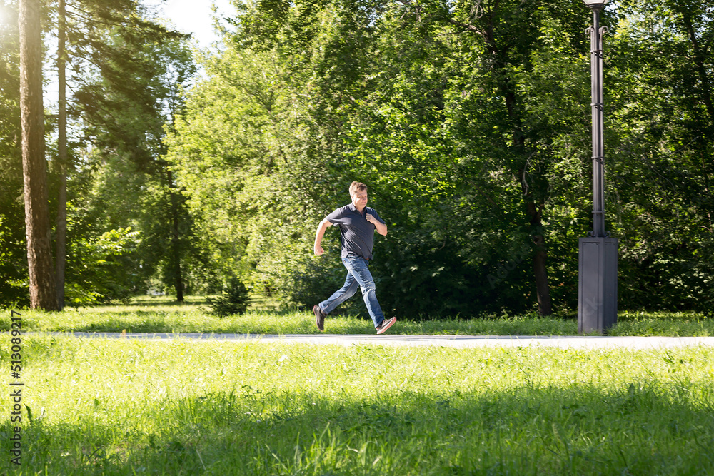 A male blond criminal runs away from the scene of the attack in the city park. A male blond criminal runs away from the scene of the attack in the city park.