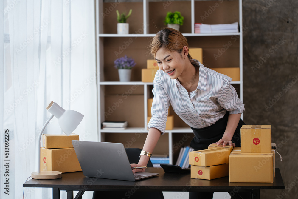 Young owner business woman live broadcast streaming for selling the products in parcel cardboard box packaging via laptop. Young owner business woman live broadcast streaming for selling the products in parcel cardboard box packaging via laptop.