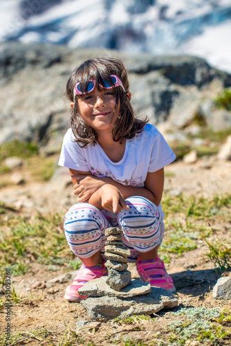 Young girl resting near a plie of rocks during a mountain excurs photo