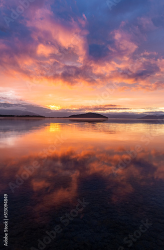 雲を染める幻想的な日没の空を湖面に映す黄昏の湖。日本の北海道の屈斜路湖。