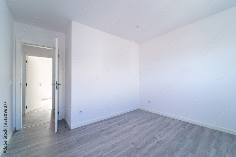 Empty room with gray wooden floating, laminate flooring. House interior, wide bedroom or living room space. New home, apartment or house. Wood floor. Real state and property management Empty room with gray wooden floating, laminate flooring. House interior, wide bedroom or living room space. New home, apartment or house. Wood floor. Real state and property management