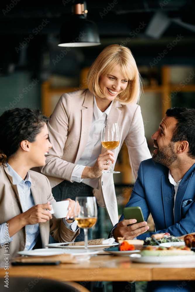 Group of happy business people have fun while drink wine and talk during lunch in restaurant. Group of happy business people have fun while drink wine and talk during lunch in restaurant.
