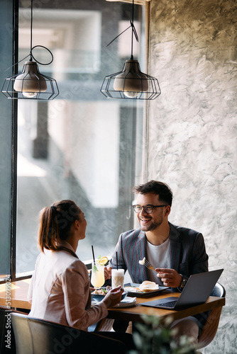 Happy businessman and his female colleague communicating during lunch break in cafe. photo