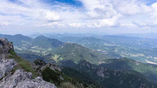 View on green hilly landscape with blue skies from the summit of a mountain, Slovakia, Europe