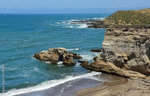 The rugged, rocky coastline and crashing waves of the california coast south of morro bay in montana de oro state park on a sunny spring day, looking out over the pacific ocean photo