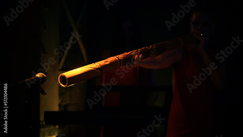 the artist plays the didgeridoo on stage. concert performance close-up microphone