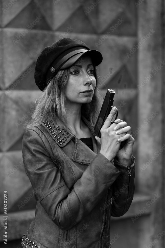 Detective woman in a cap with a gun in black and white Detective woman in a cap with a gun in black and white