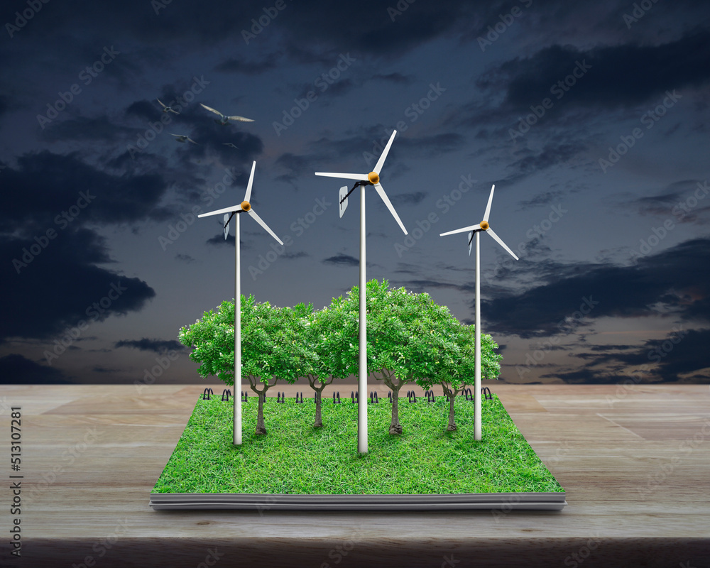 Obraz premium Wind turbines, trees, grass and birds from an open book on wooden table over sunset sky, Business ecological energy concept