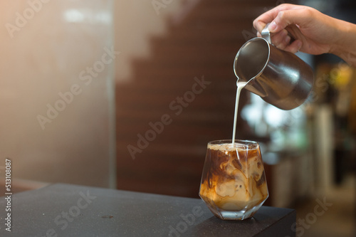 Barista pouring coffee in glass