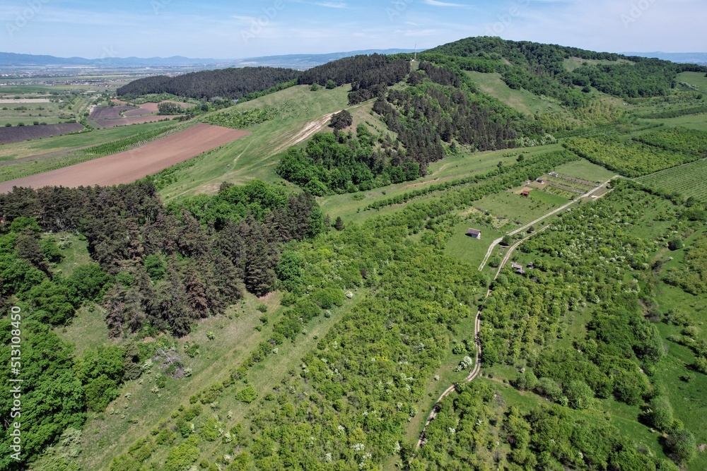 Aerial view of agricultural land covering uneven terrain of hills