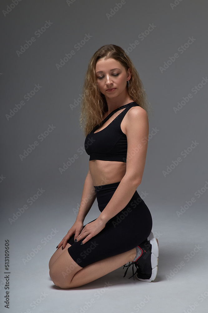 young fit sporty attractive caucasian female in sportswear sitting on her knees young fit sporty attractive caucasian female in sportswear sitting on her knees