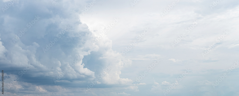 Fototapeta premium Cloudy sky with picturesque gray and blue clouds through which sunlight shines
