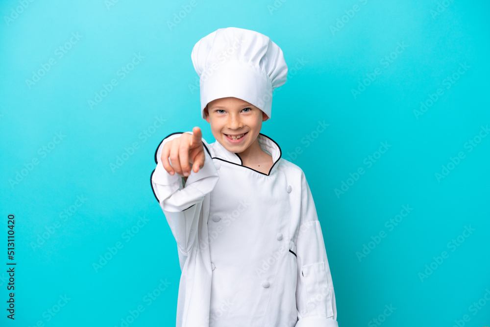 Little chef boy isolated on blue background pointing front with happy expression Little chef boy isolated on blue background pointing front with happy expression