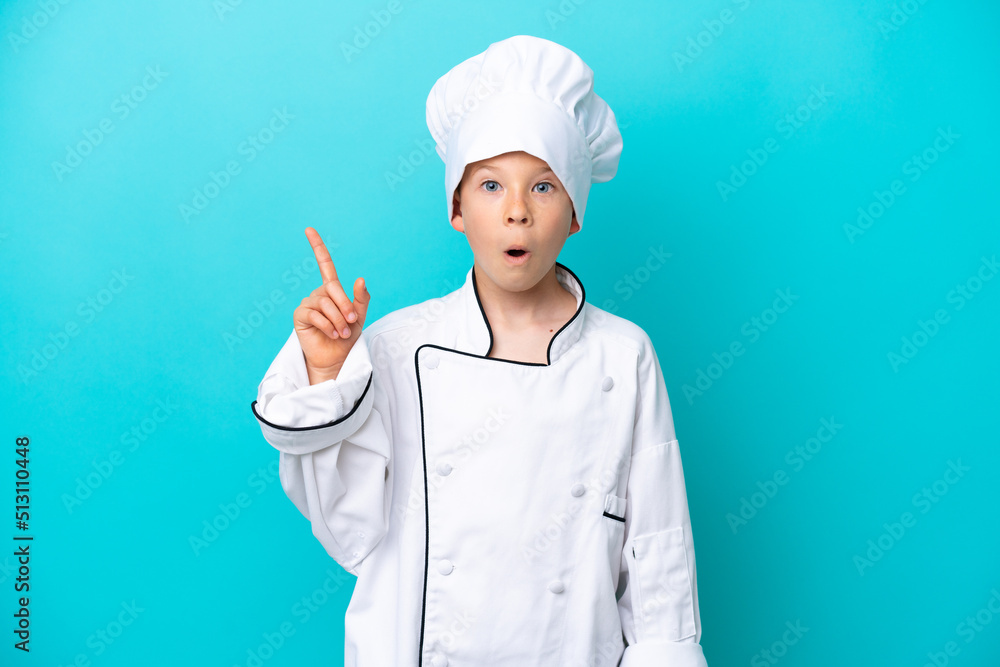 Little chef boy isolated on blue background intending to realizes the solution while lifting a finger up Little chef boy isolated on blue background intending to realizes the solution while lifting a finger up