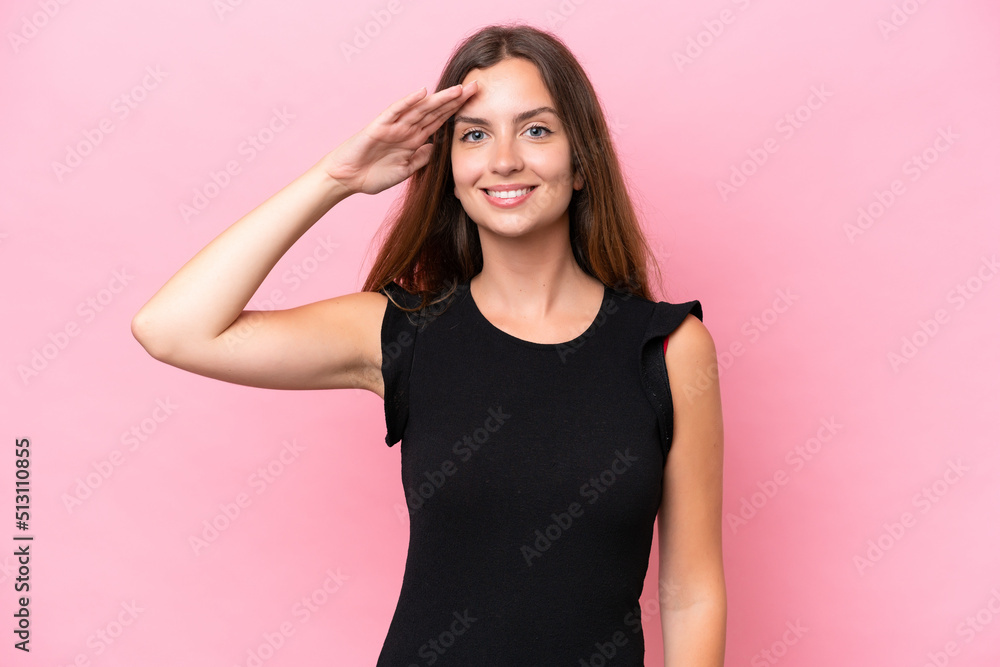 Young caucasian woman isolated on pink background saluting with hand with happy expression Young caucasian woman isolated on pink background saluting with hand with happy expression