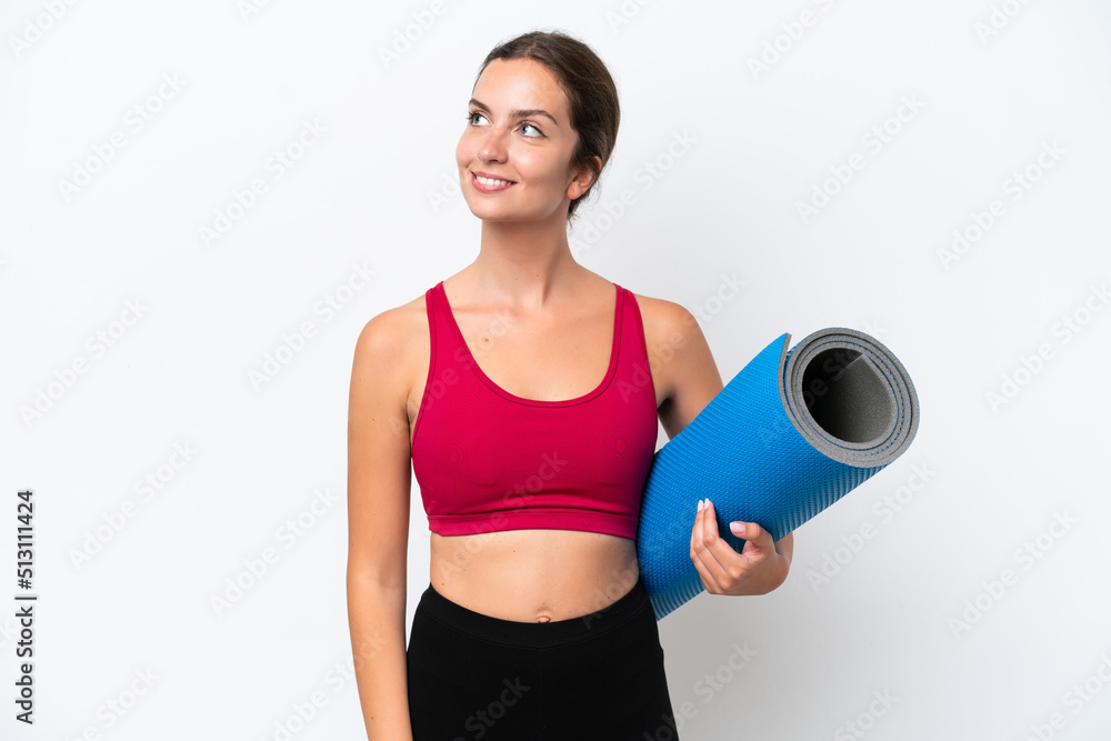 Young sport caucasian woman going to yoga classes while holding a mat isolated on white background thinking an idea while looking up Young sport caucasian woman going to yoga classes while holding a mat isolated on white background thinking an idea while looking up