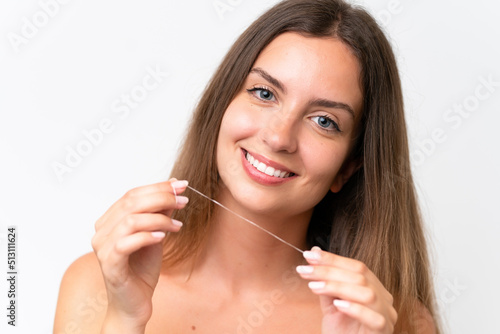 Young caucasian woman isolated on white background using dental floss with happy expression. Close up portrait