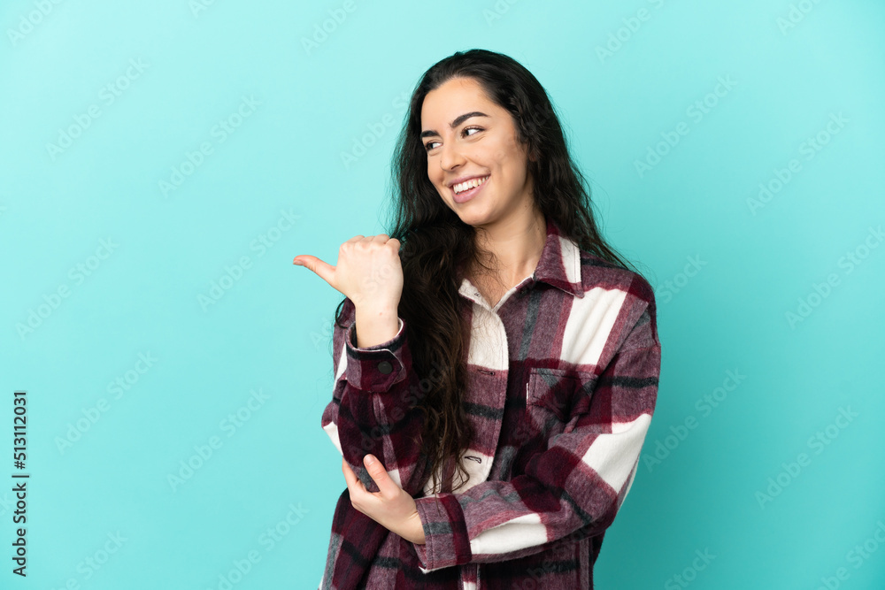 Young caucasian woman isolated on blue background pointing to the side to present a product Young caucasian woman isolated on blue background pointing to the side to present a product