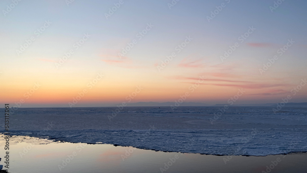 Sunset over the frozen sea in winter