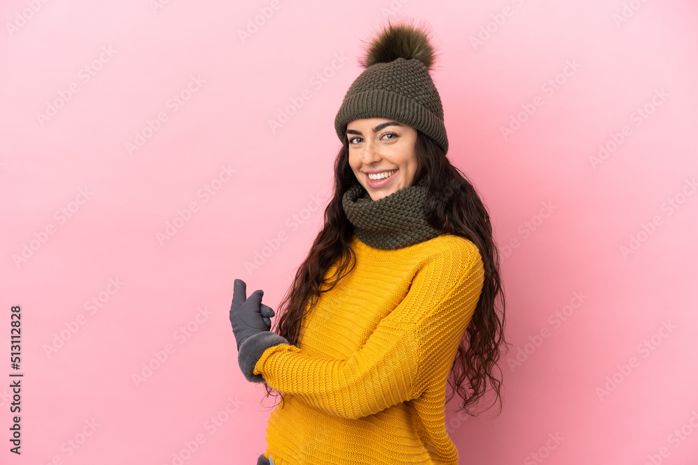 Young caucasian girl with winter hat isolated on purple background pointing back Young caucasian girl with winter hat isolated on purple background pointing back