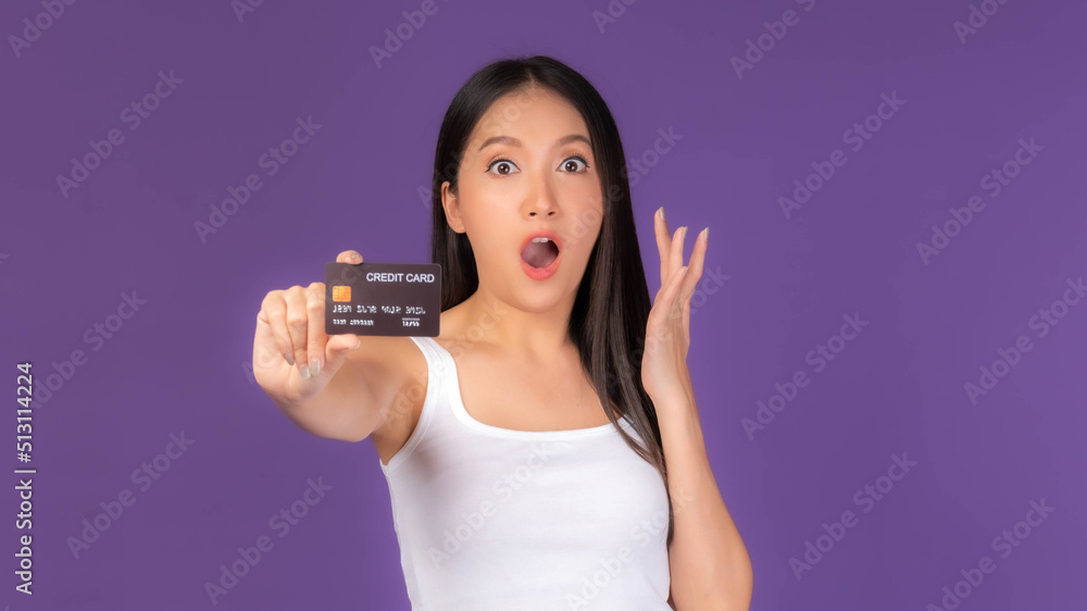 Beautiful Asian brunette woman cute girl in white tank top Excited surprised girlshowing credit card for payment shopping online , credit card online shopping  e-commerce telemarketing concept