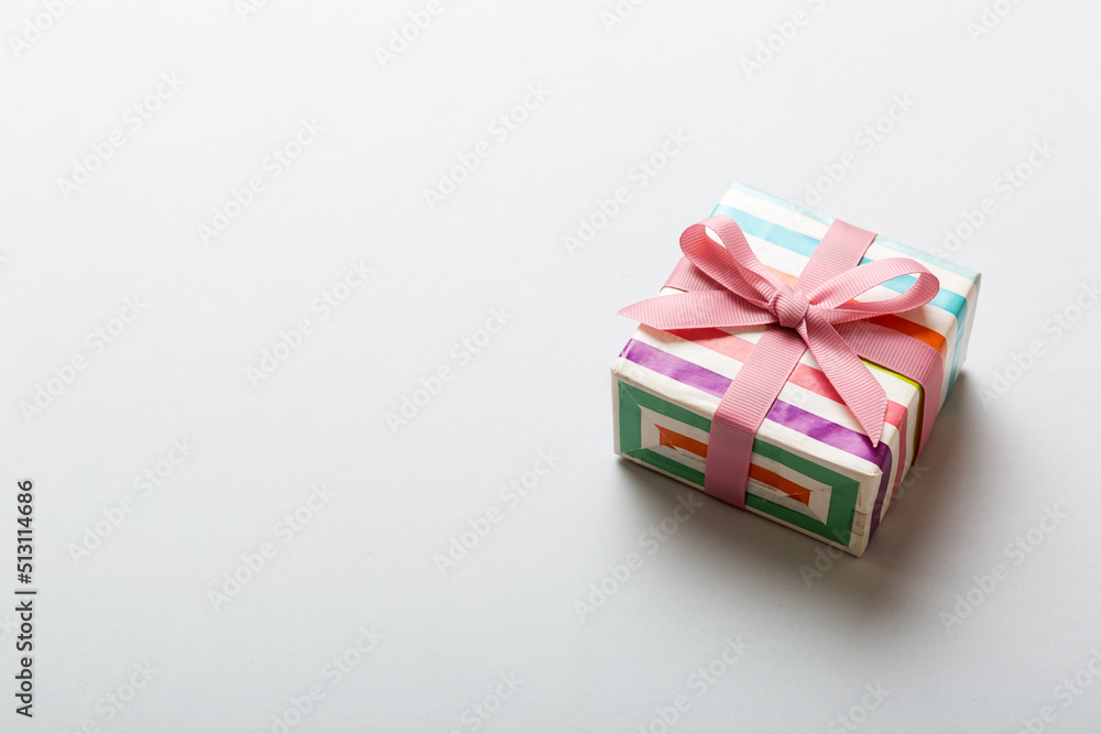 wrapped Christmas or other holiday handmade gift box in color paper with ribbon on colored background. Present box, decoration of gift on colored table, top view with copy space wrapped Christmas or other holiday handmade gift box in color paper with ribbon on colored background. Present box, decoration of gift on colored table, top view with copy space