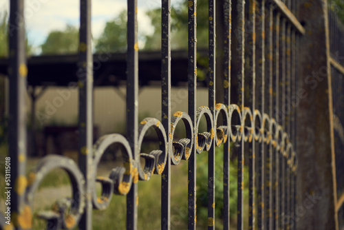 Weathered metal fence, old building