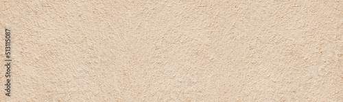 Old rough weathered plaster wide texture. Light golden beige painted textured cement aged cracked wall. Pastel color abstract panoramic grunge background