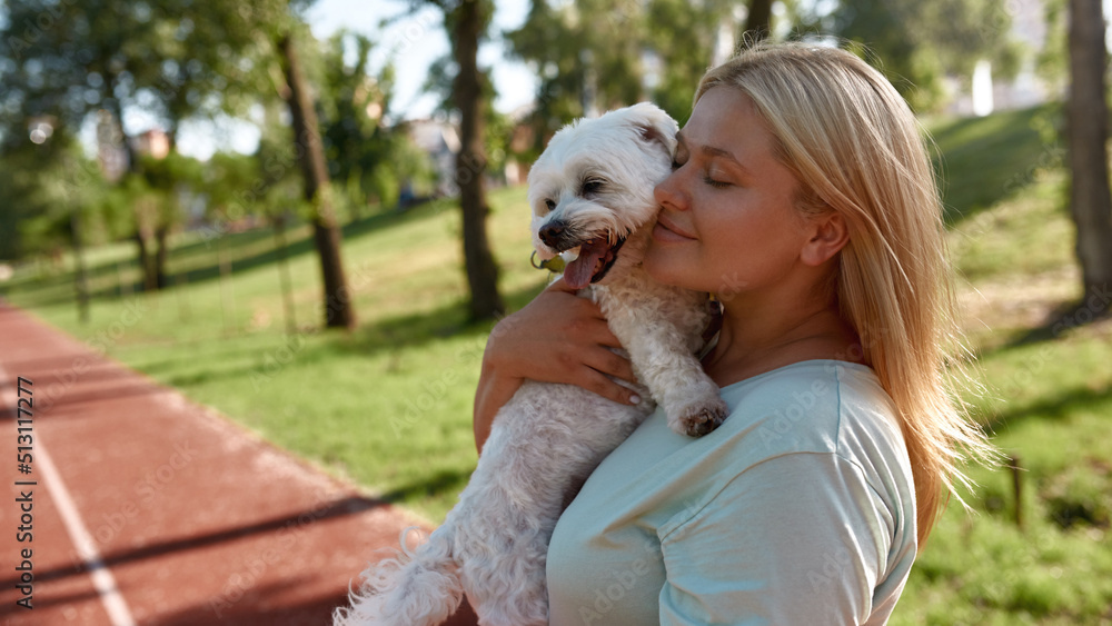 Young smiling caucasian girl hugging Maltese dog Young smiling caucasian girl hugging Maltese dog