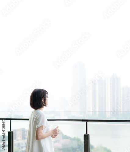 Asian woman standing on balcony
