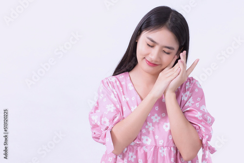 Portrait Asian beautiful woman in pink dress and black long hair. Her hands touch cheek, close her eyes and smile, show beautiful skin on white background.